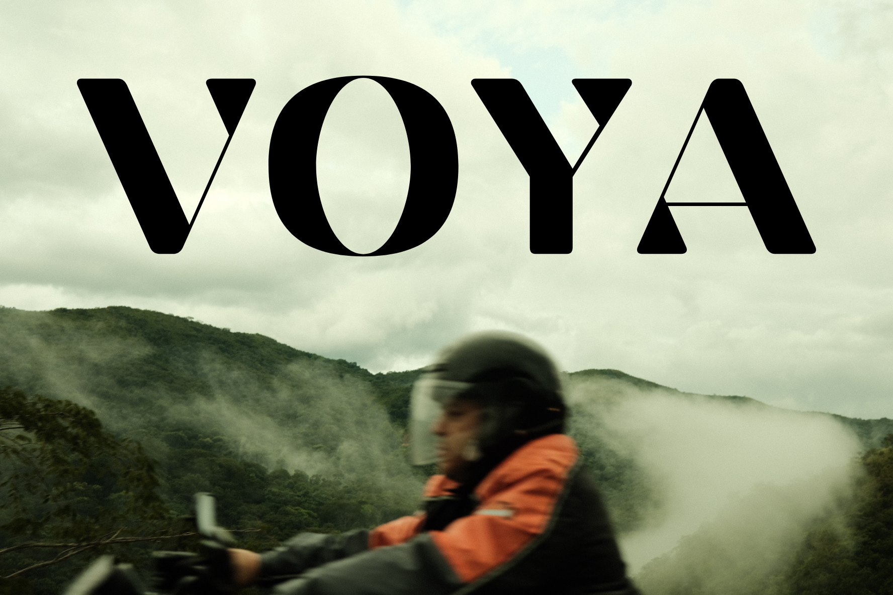 VOYA sobre un viajero en motocicleta entre montañas y niebla